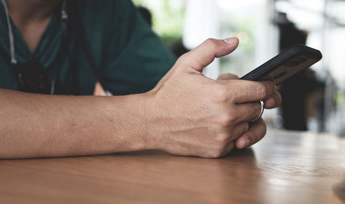 Midsection of man using mobile phone