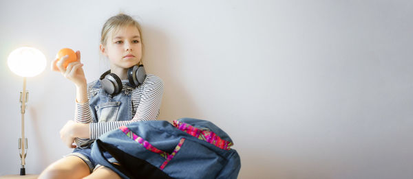 Girl sitting against wall