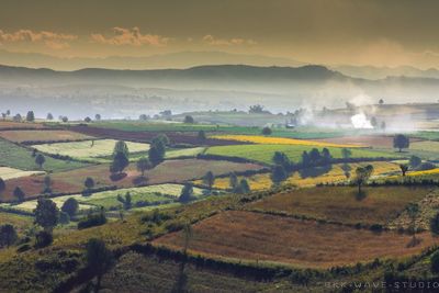 Scenic view of field against cloudy sky