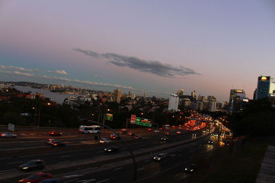 High angle view of illuminated street amidst buildings against sky