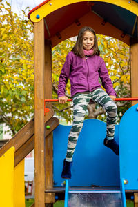 Full length of girl sitting on jungle gym