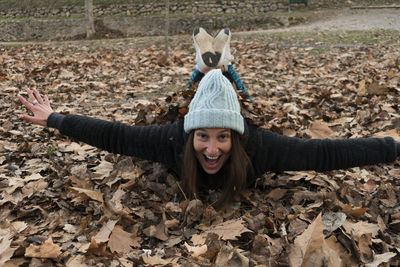 Portrait of a smiling young woman with autumn leaves