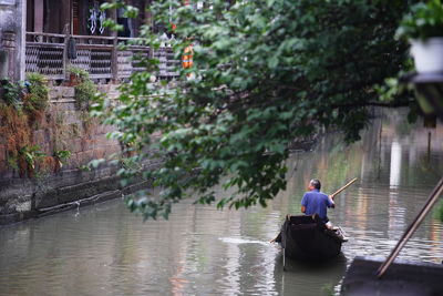 Rear view of man sitting in water