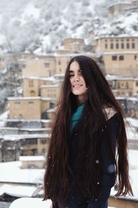 Portrait of smiling young woman standing in snow