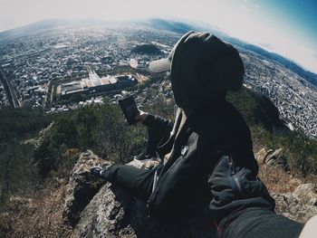Midsection of woman photographing against sky