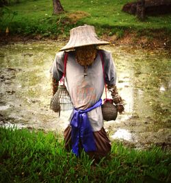 Full length of man wearing hat in basket on field