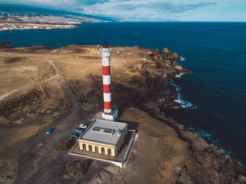 High angle view of lighthouse by sea against sky