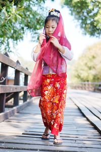 Full length of girl standing against pink umbrella