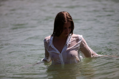 Sensual young woman swimming in lake