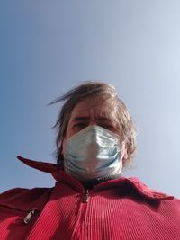 Low angle portrait of person against clear sky