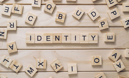 Word identity made with letter blocks on wooden background