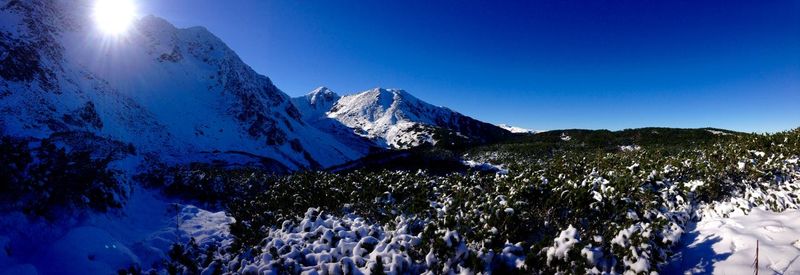 Scenic view of snow covered mountains against clear sky