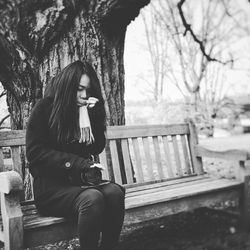 Full length of woman sitting at park