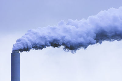 Smoke emitting from chimney against sky