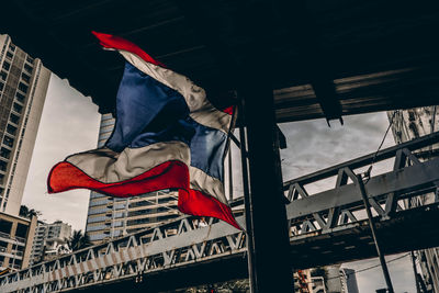 Low angle view of flags hanging against sky