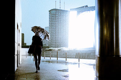 Full length of woman standing in city during rainy season