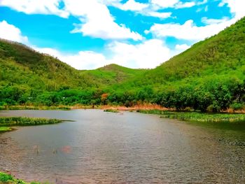 Scenic view of lake by mountains against sky