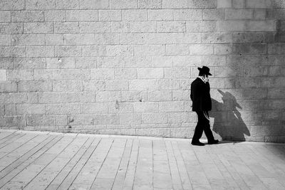 Rear view of woman standing against wall