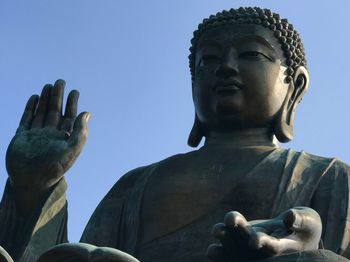 Low angle view of buddha statue against sky