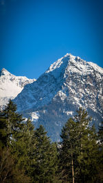 Scenic view of snowcapped mountains against clear blue sky