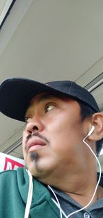 Close-up portrait of young man wearing hat