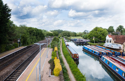 High angle view of railroad tracks by canal against sky