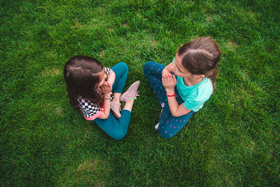 High angle view of woman sitting on grassy field