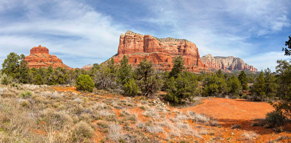 Rock formations on landscape against cloudy sky