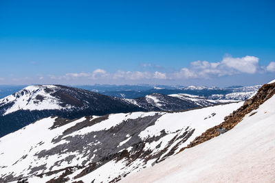 Scenic view of snowcapped mountains against blue sky