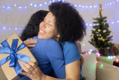 Happy young woman in illuminated christmas lights