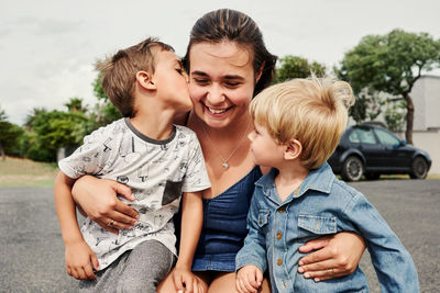 Cute boy kissing mother outdoors