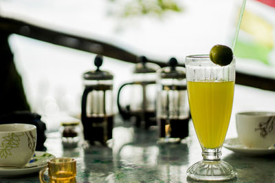 Close-up of pineapple juice and coffee on table