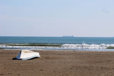 Deck chairs on beach against clear sky