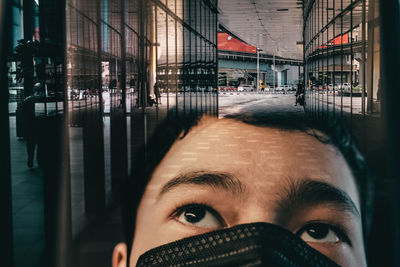 Double exposure of a boy wearing face mask in the city