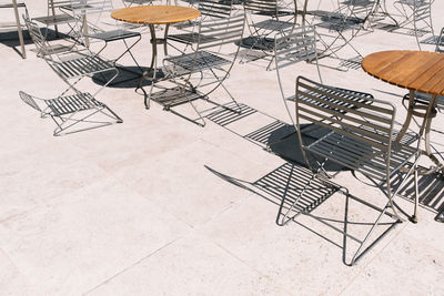 Empty chairs and tables on sidewalk cafe