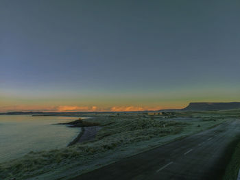 Scenic view of beach against clear sky during sunset