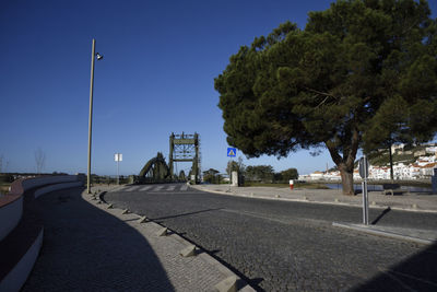 Road by trees against clear sky