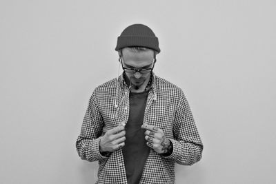 Man wearing eyeglasses standing against white background