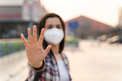 Portrait of woman standing against blurred background