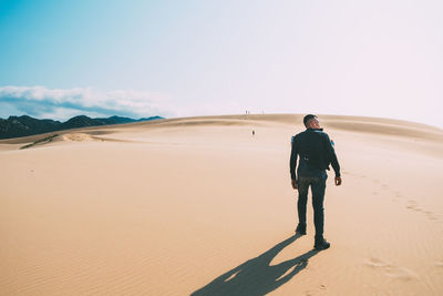 Full length of man standing on sand dune