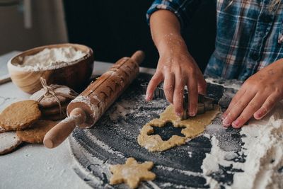 Small hands pressing dough out with cookie cutters - christmas