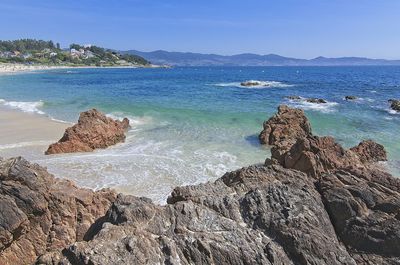 Scenic view of rocks on beach against sky