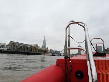 Red ship in water against sky