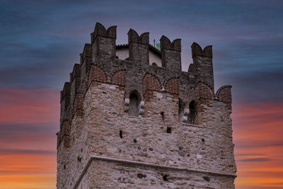 Low angle view of old building against sky during sunset