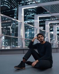 Portrait of young man sitting against window