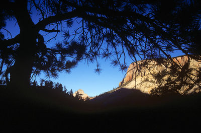 Low angle view of silhouette mountains against clear blue sky