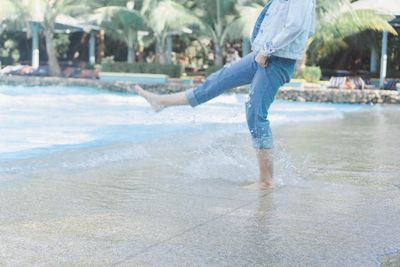 Full length of boy walking on wet beach