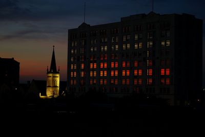 Silhouette of buildings against sky at night