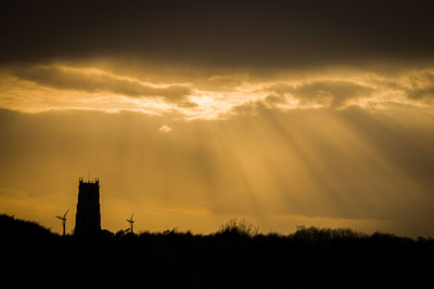 Low angle view of silhouette tower against sky during sunset