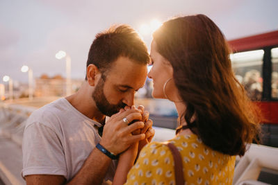 Man kissing girlfriends hand outdoors